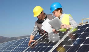 Two professionals inspecting solar panels