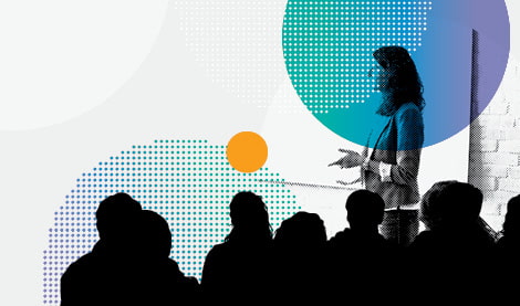 A trainer presenting to an audience of teachers at a professional development event